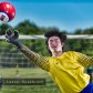 A goalie for a soccer team uses his hand to knock a ball away from the goal