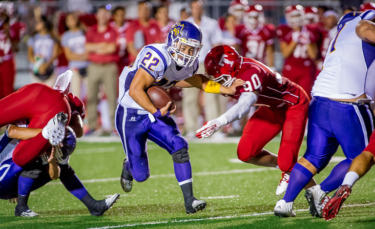 Laredo LBJ running back #22 Juan Cisneros, pushes his way past Taft defensive end Brian Ukaegbu during a game at Gustafson stadium.  Taft held on to win 21-14.