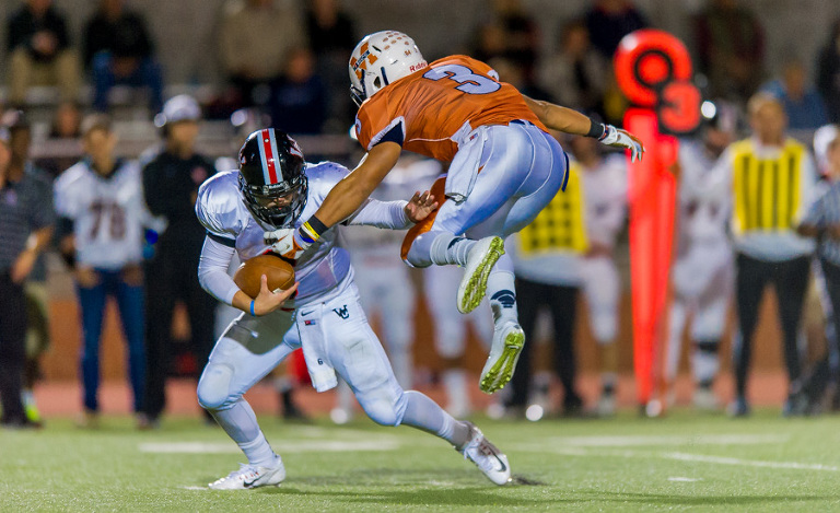 Churchill quarterback David Montoya dodges Madison defense in the final game of the regular season. Madison won the game 14 - 7.